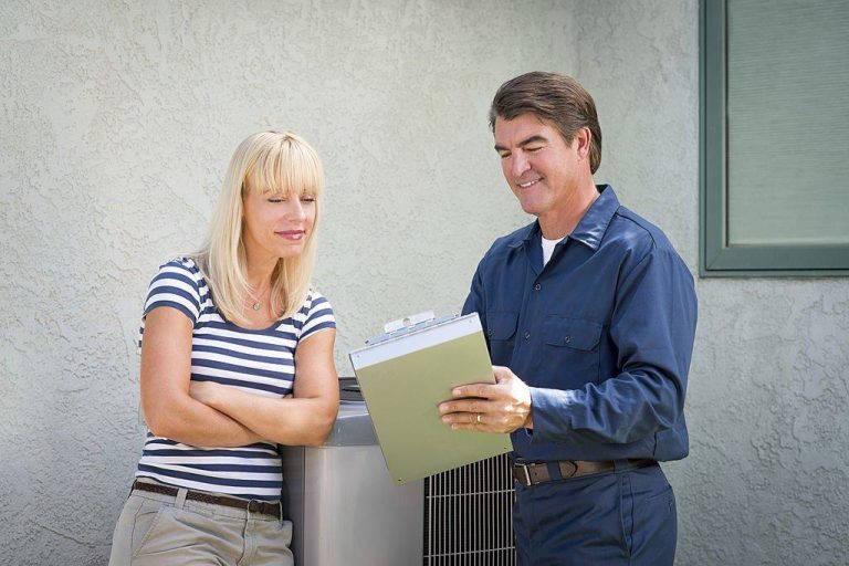 Air conditioner technician servicing mini-split heat pump on roof top